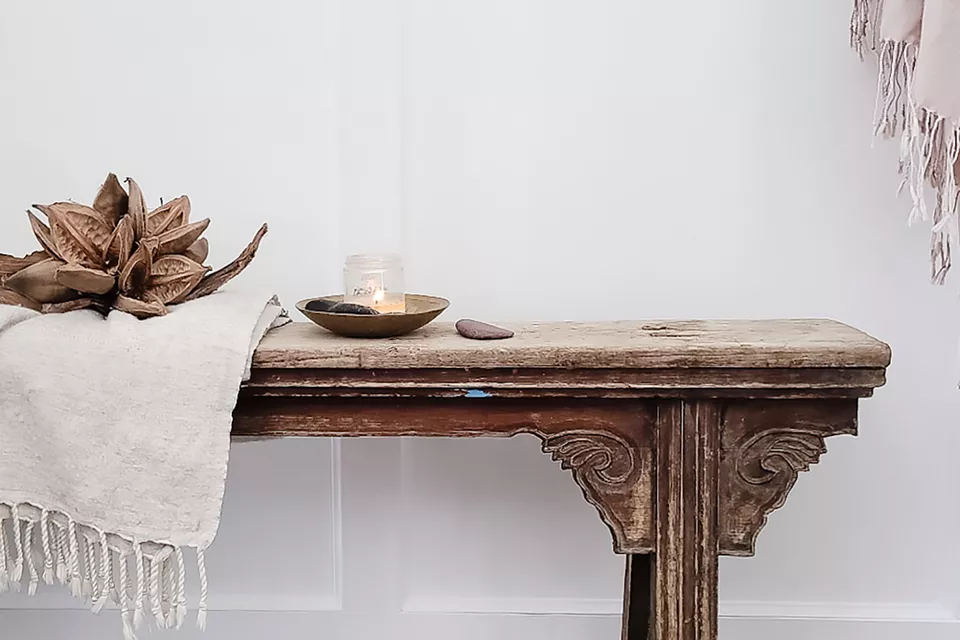 一個日式木凳，上面有一個投擲物和蠟燭。 